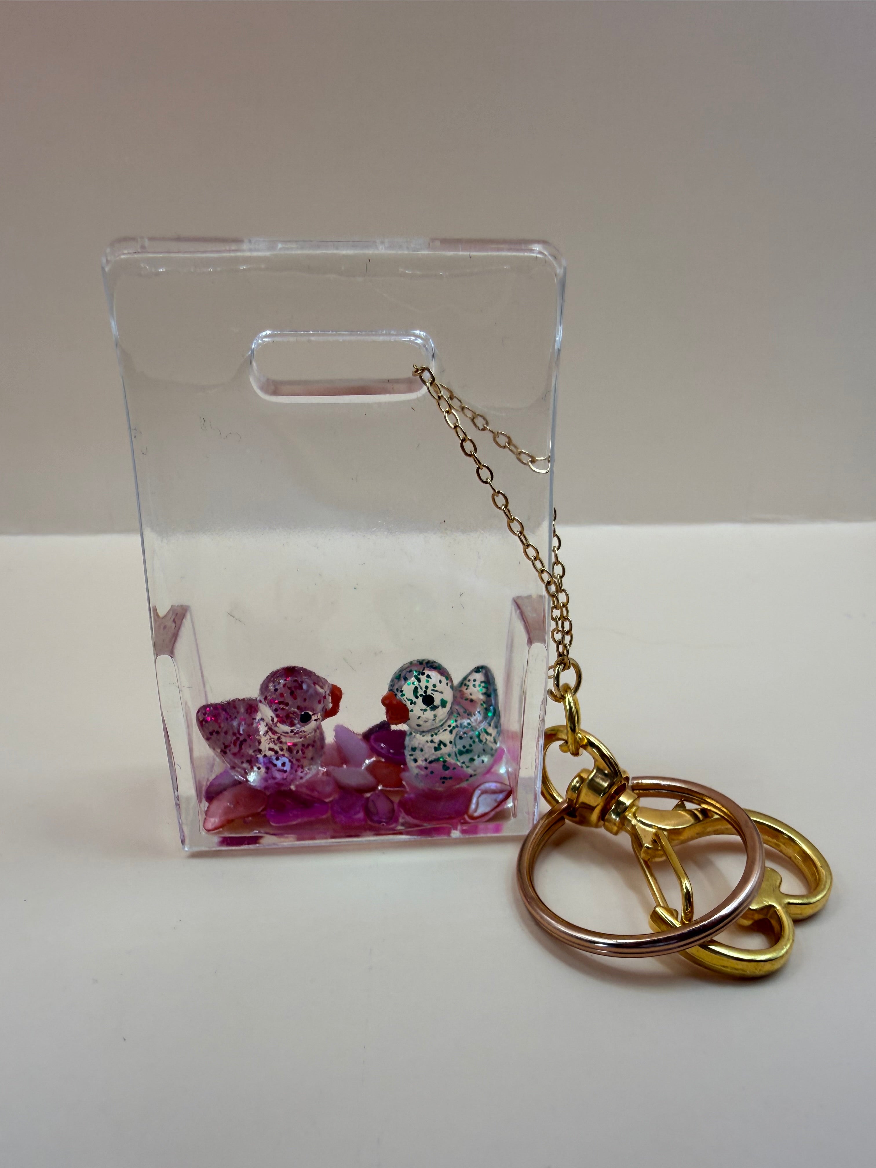Unieke handgemaakte transparante sleutelhanger met lieve eendjes en steentjes. Leuk voor aan je sleutelbos, tas of als persoonlijk cadeautje van By Jaike.